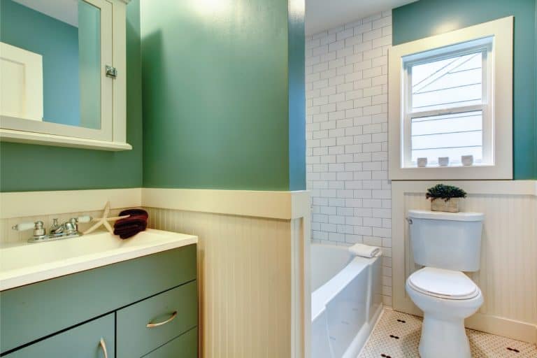 Seafaring Beauty. cruise ship style bathroom with painted wood panels, teal wall, nautical accents