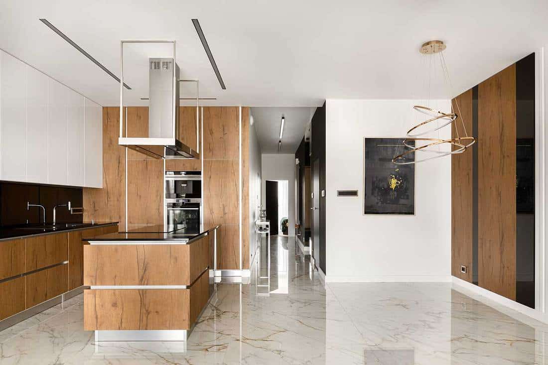 Spacious kitchen with big kitchen island, wooden elements and marble floor