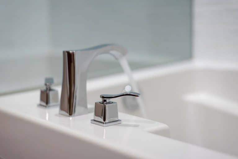 Stainless steel bathtub faucet of a white bathtub, 12 Types Of Bathtub Faucets [And Faucet Handles]