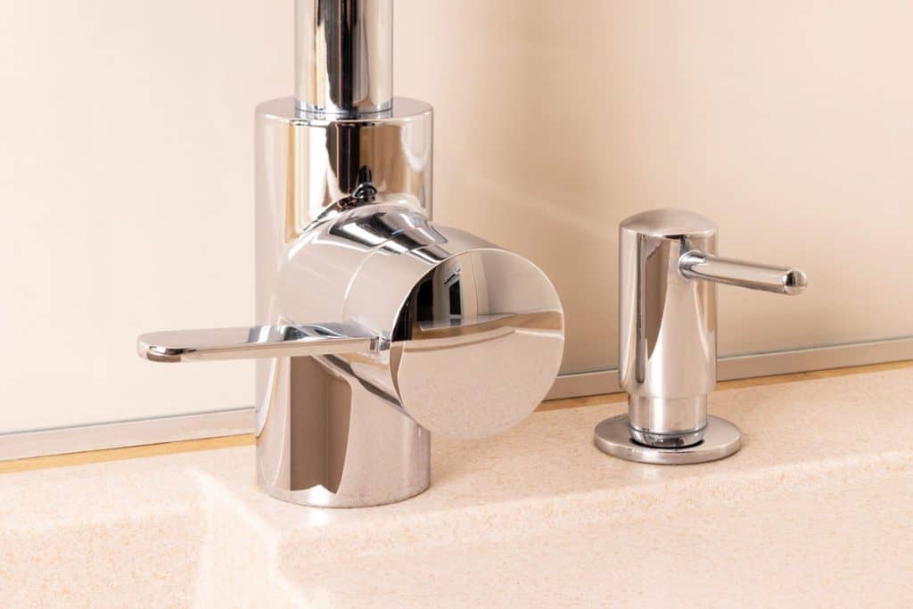 Stainless steel faucet and sink mounted soap dispenser on the side, How Far Should A Soap Dispenser Be From The Faucet?