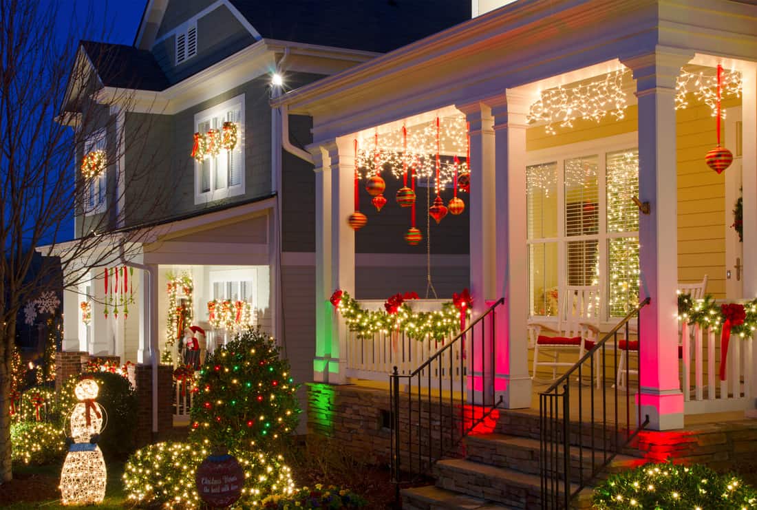  These traditional, Victorian-style, wood-sided homes are beautifully and tastefully decorated for the Holiday Season. Each window has a single candle glowing and wreaths with red bows hang from the front door and windows. 