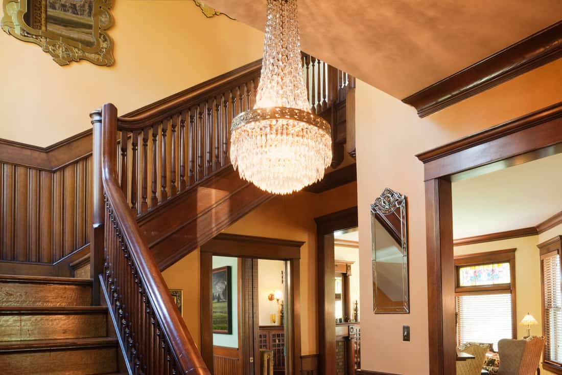 The interior foyer or entryway of an old restored Victorian style home, with oriental rugs and period furniture