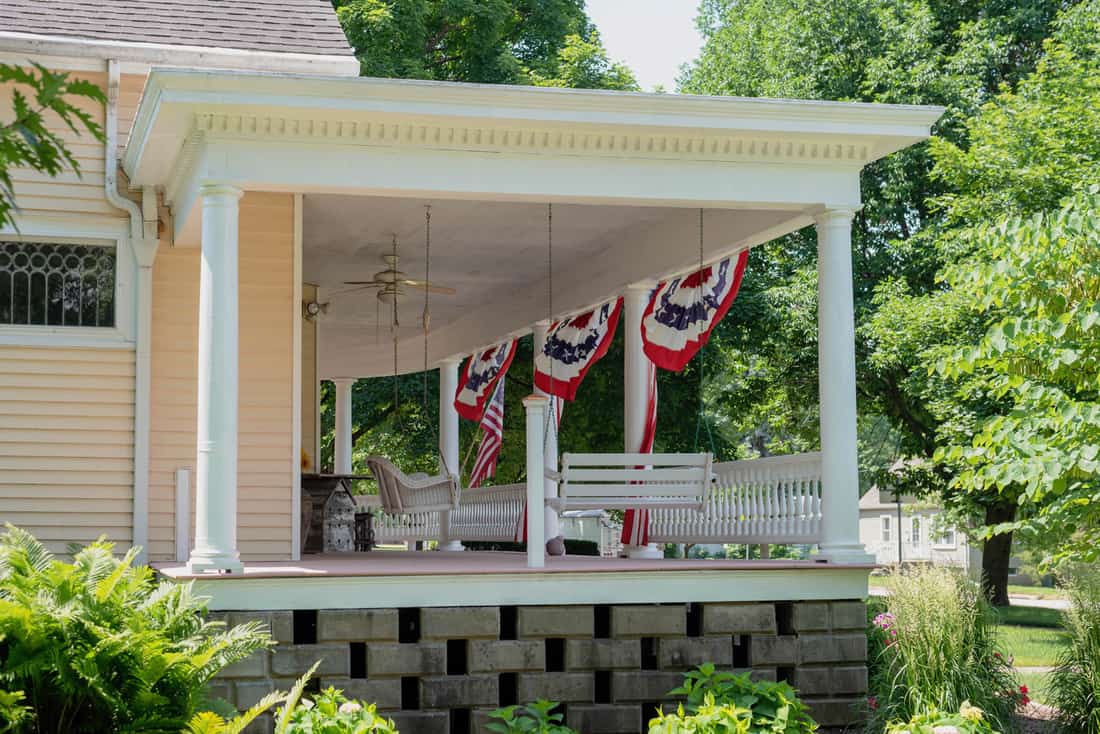 Traditional home with charming front porch decorated for the Fourth of July