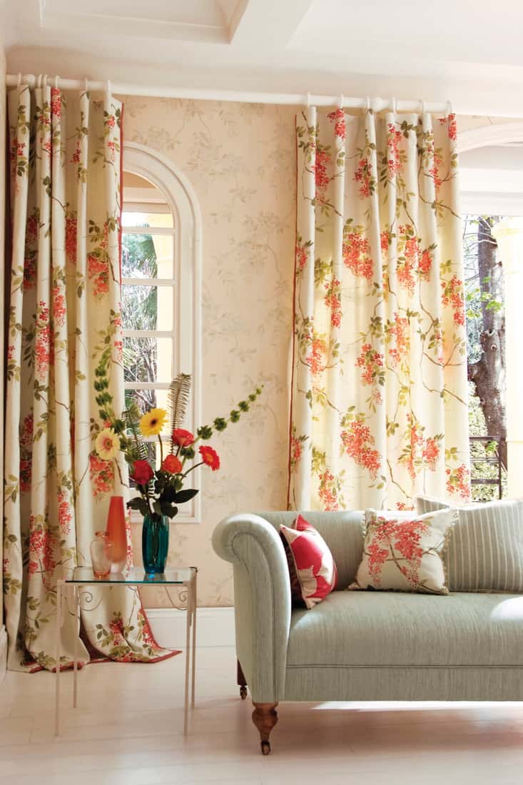 Traditional lounge living room with sofa, with pretty floral curtains and ornaments