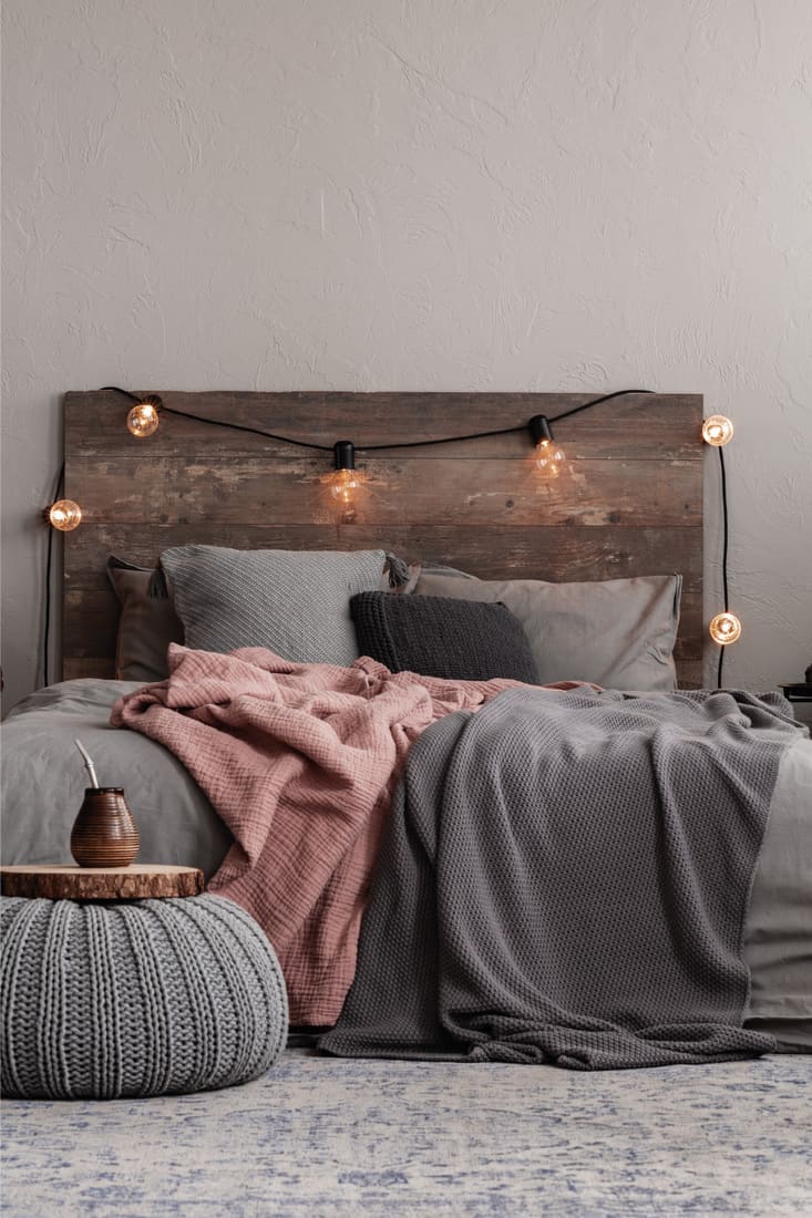 Trendy rustic bedroom design with grey and pastel pink bedding creating a country charm ambiance