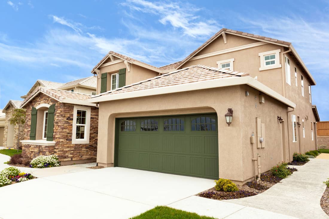 Vue sur la maison moderne et haut de gamme de la banlieue californienne avec garage, la porte de garage devrait-elle être de la même couleur que la maison ?