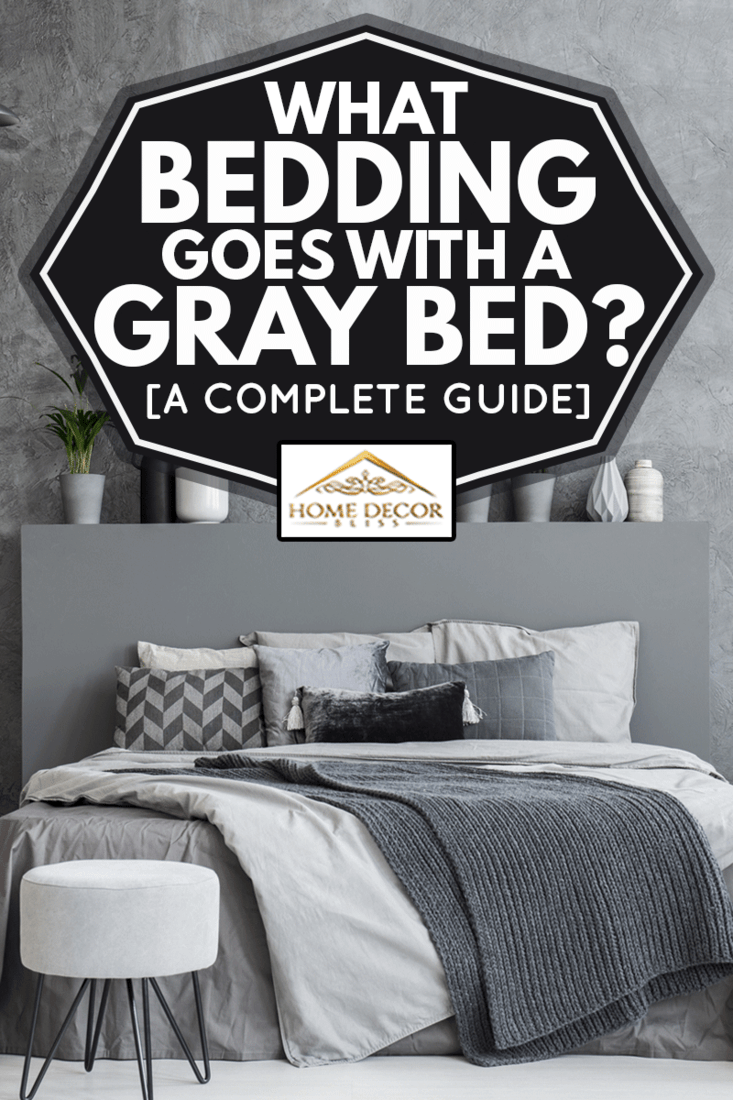 Grey stool in front of bed with blankets and cushions in dark hotel bedroom interior, What Bedding Goes With A Gray Bed? [A Complete Guide]
