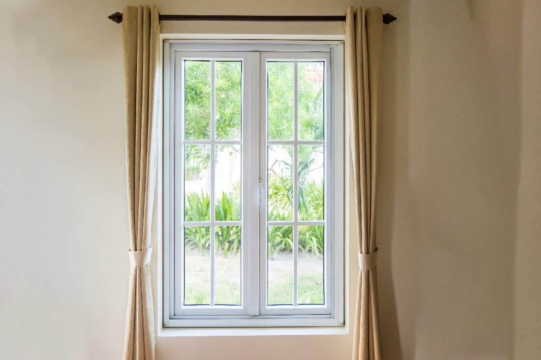 White frame windows with brown curtain