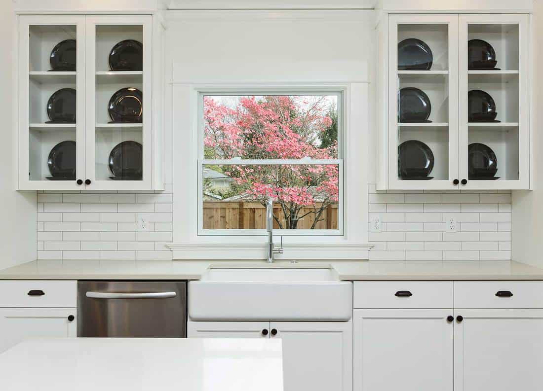 White kitchen with sink and blooming dogwood