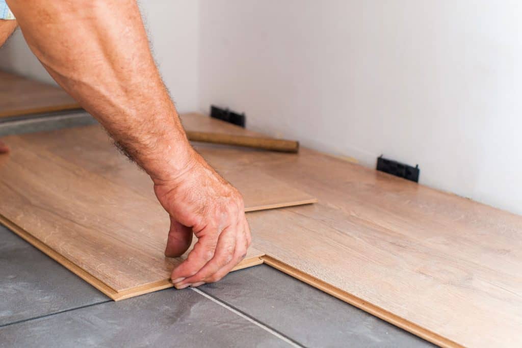 Worker installing wooden vinyl flooring