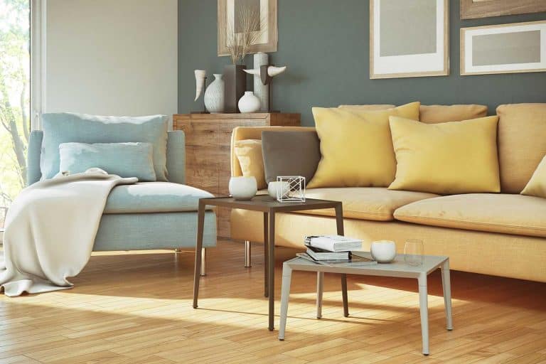 Yellow sofa and blue chair of cozy living room with parquet floor