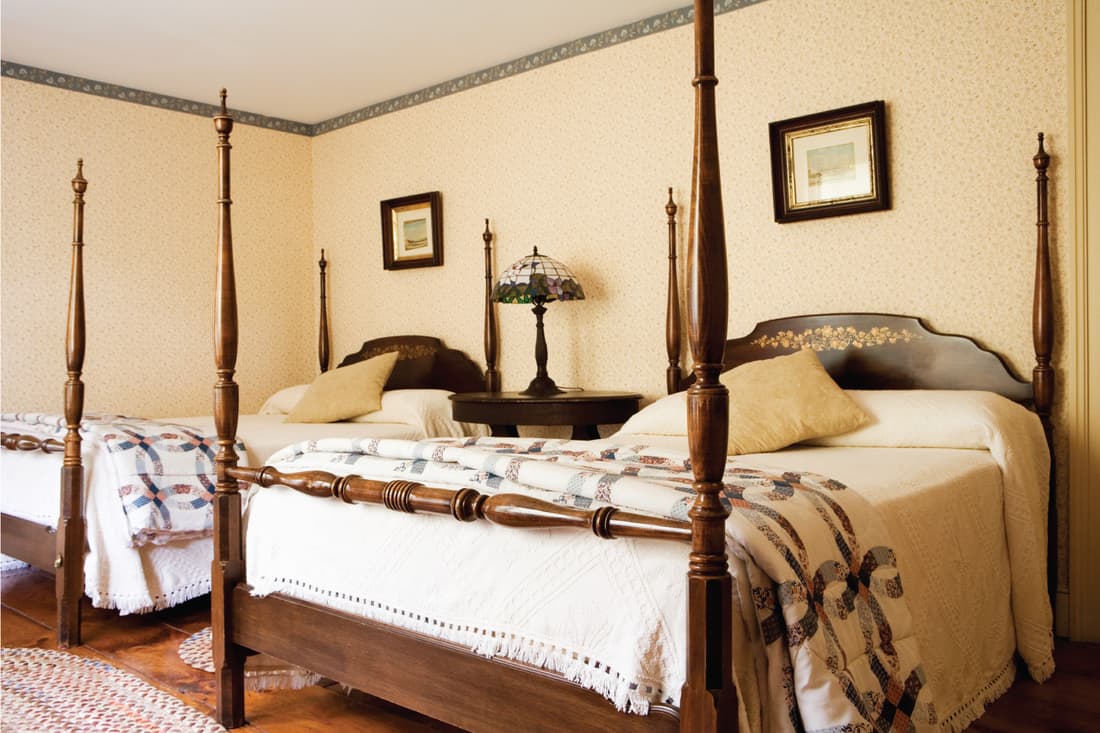 antique-heavy bedroom features a lot of tan, mahogany wood, and rose undertones. Country Victorian