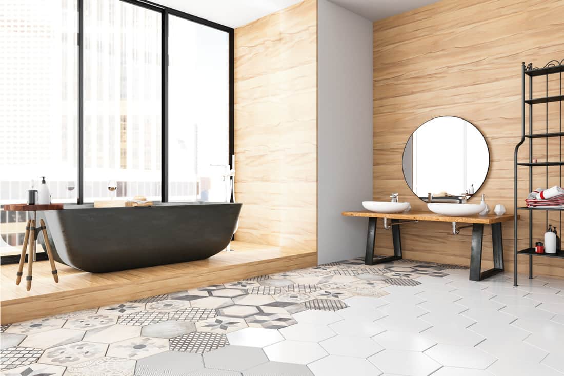 Bathroom with large gray bath tub and geometric gradient floor tiles