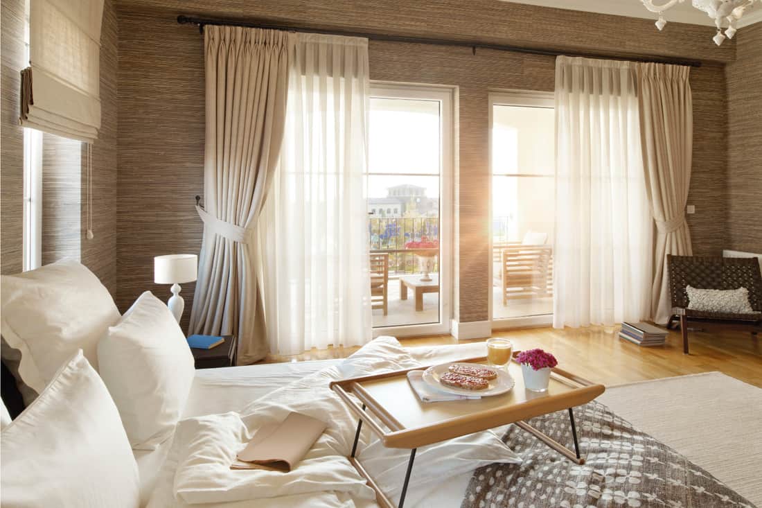 Chambre confortable avec petit-déjeuner au lit et rideaux transparents et occultants, le meilleur des deux mondes