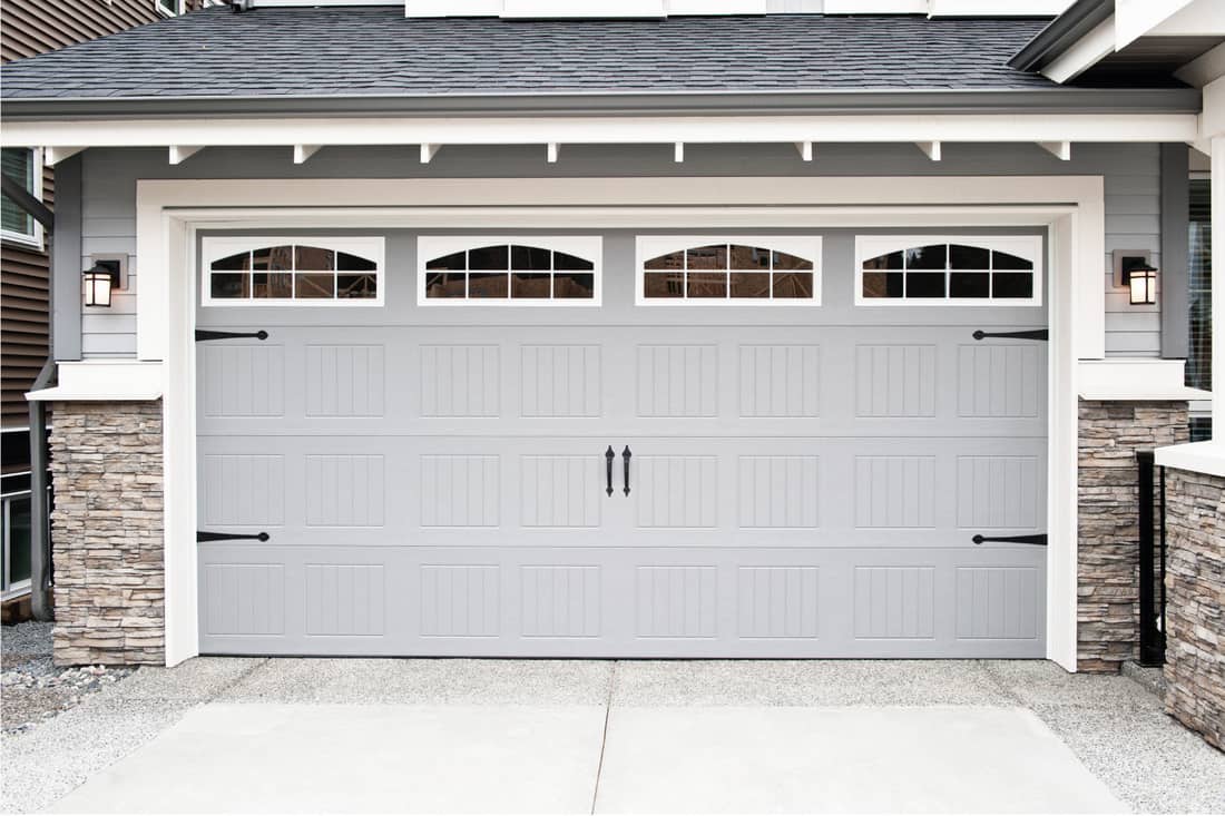 gray and white garage door with stone wall claddings