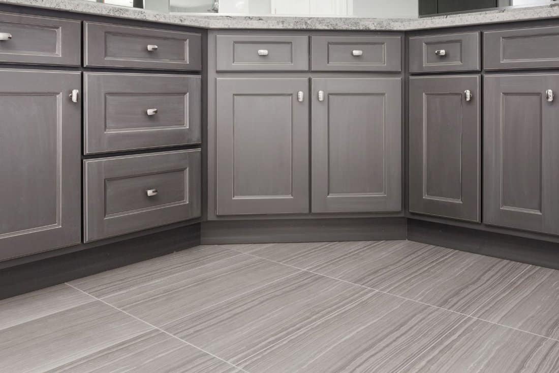 gray shaker style kitchen / vanity / bathroom cabinet with chrome color rectangular handles, porcelain floor tiles
