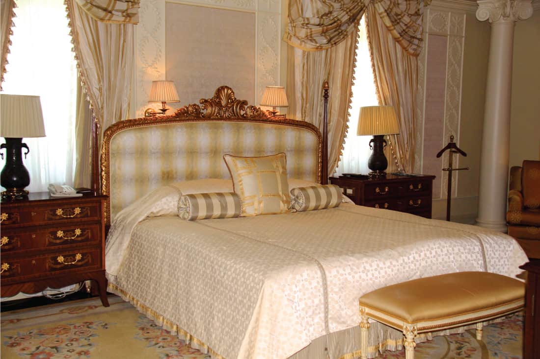 hotel bedroom in old school, Rococo or Baroque decor, silk and satin beddings and curtains