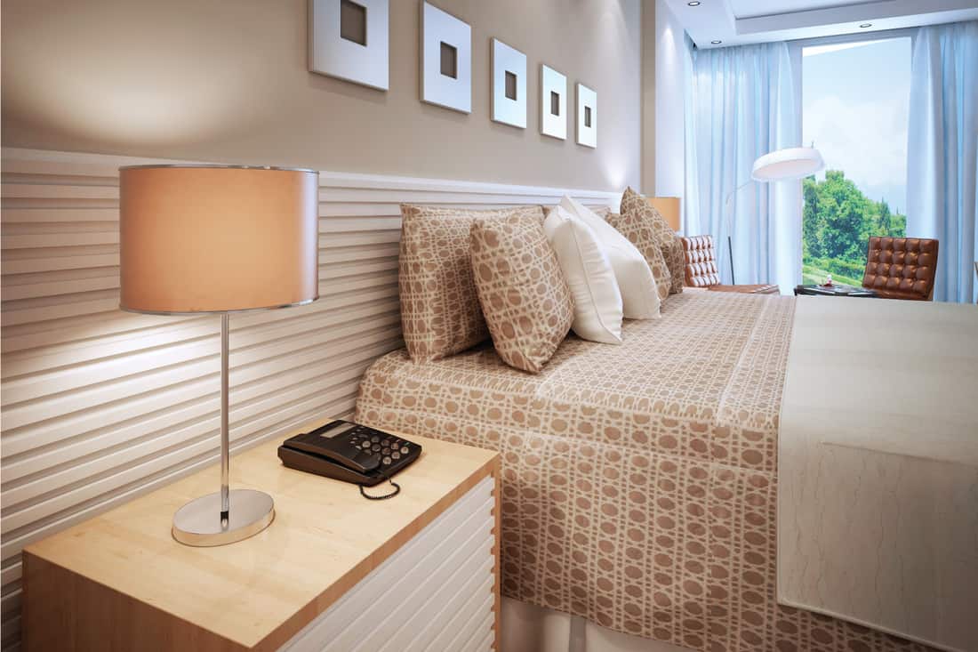 rich in texture bedroom with white and tan accent. patterned wall and beddings, wood nightstand