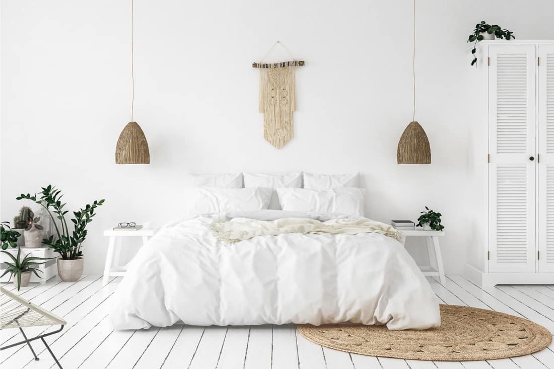 Scandinavian boho style bedroom with white walls, white bed and white beddings