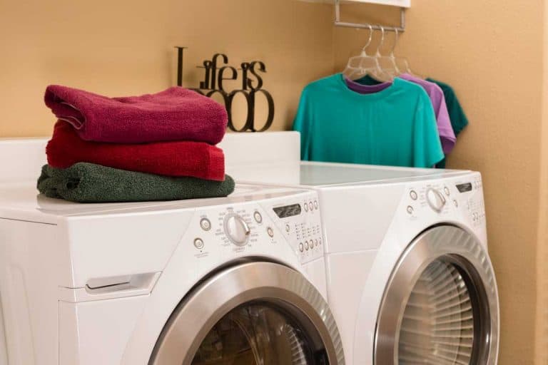 A laundry room with towels folded and clothes hung to dry, 7 Great Laundry Room Hanging Ideas