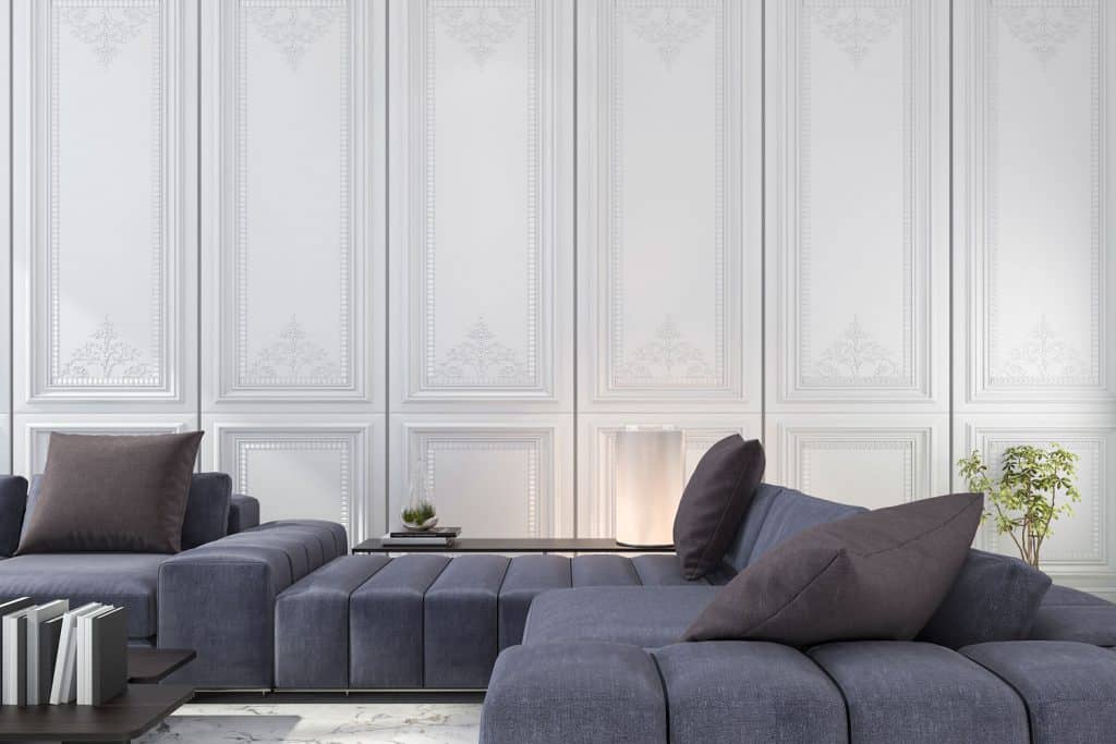 A long purple sectional sofa inside a white flat paneled wall living room
