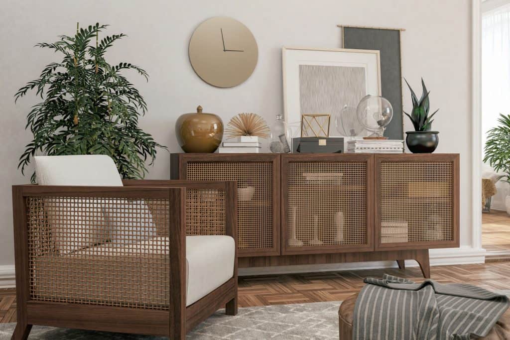 A modern Scandinavian themed living room with a wooden screened sideboard with furniture's on top