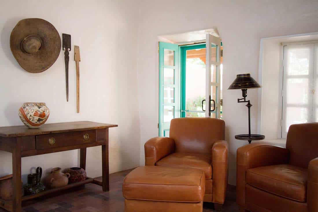 Adobe room with southwest decor and brown leather sofa chairs
