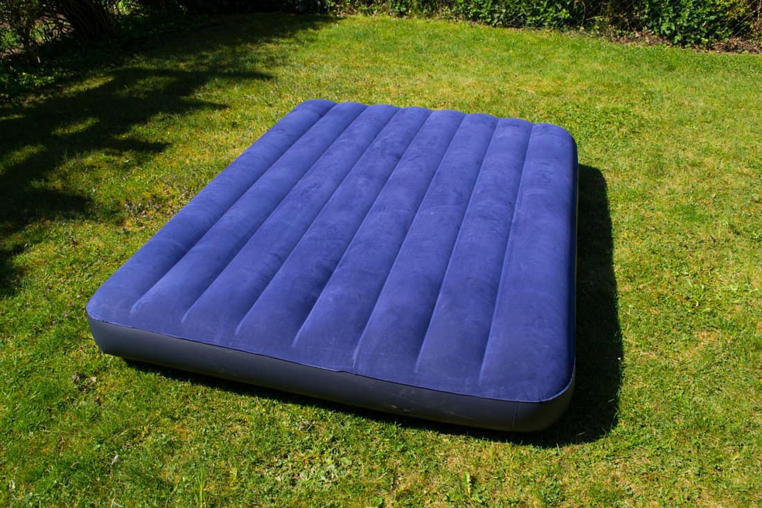 An air mattress left on the grass