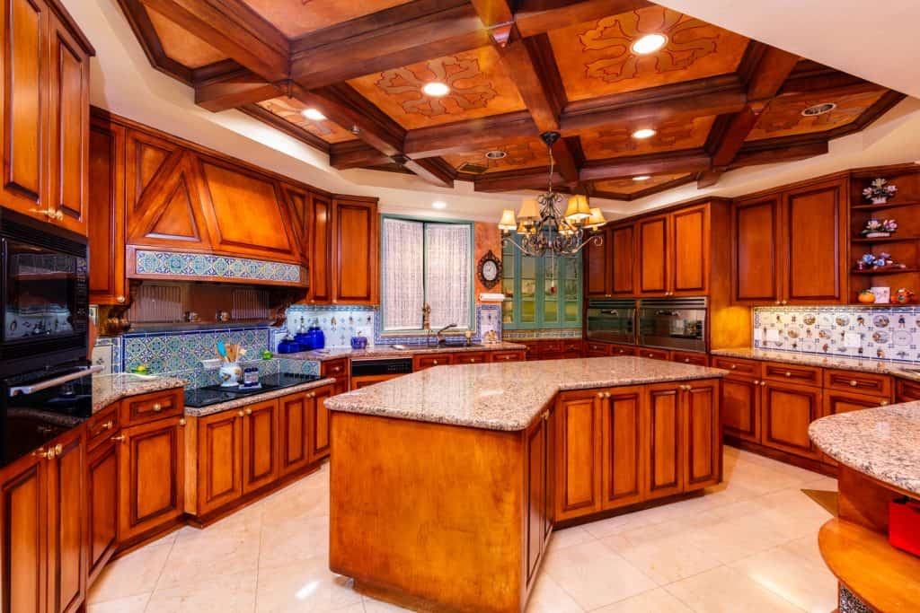 Beautiful luxury home kitchen with red cherry wood cabinets.