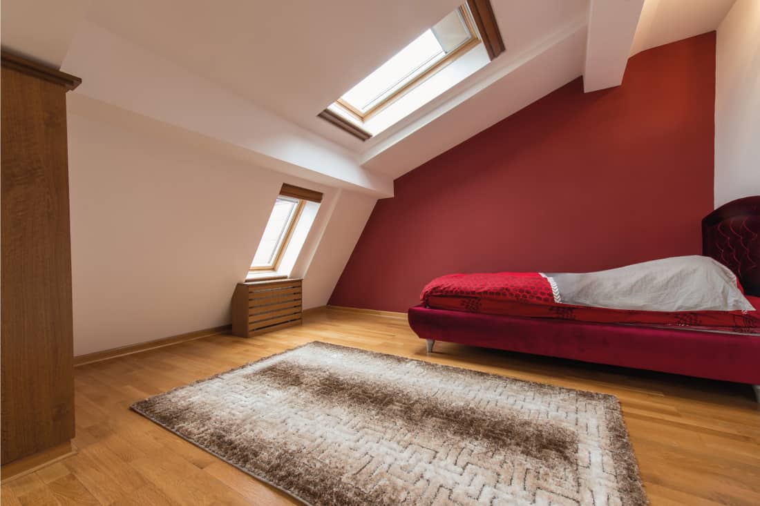 Bedroom interior in luxury red loft, attic, apartment with roof. Does An Attic Count As A Bedroom