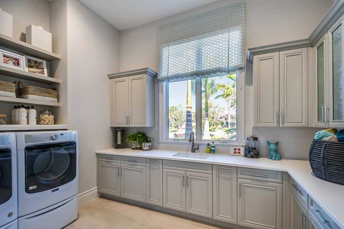 Big laundry room with plenty of cabinets and shelves
