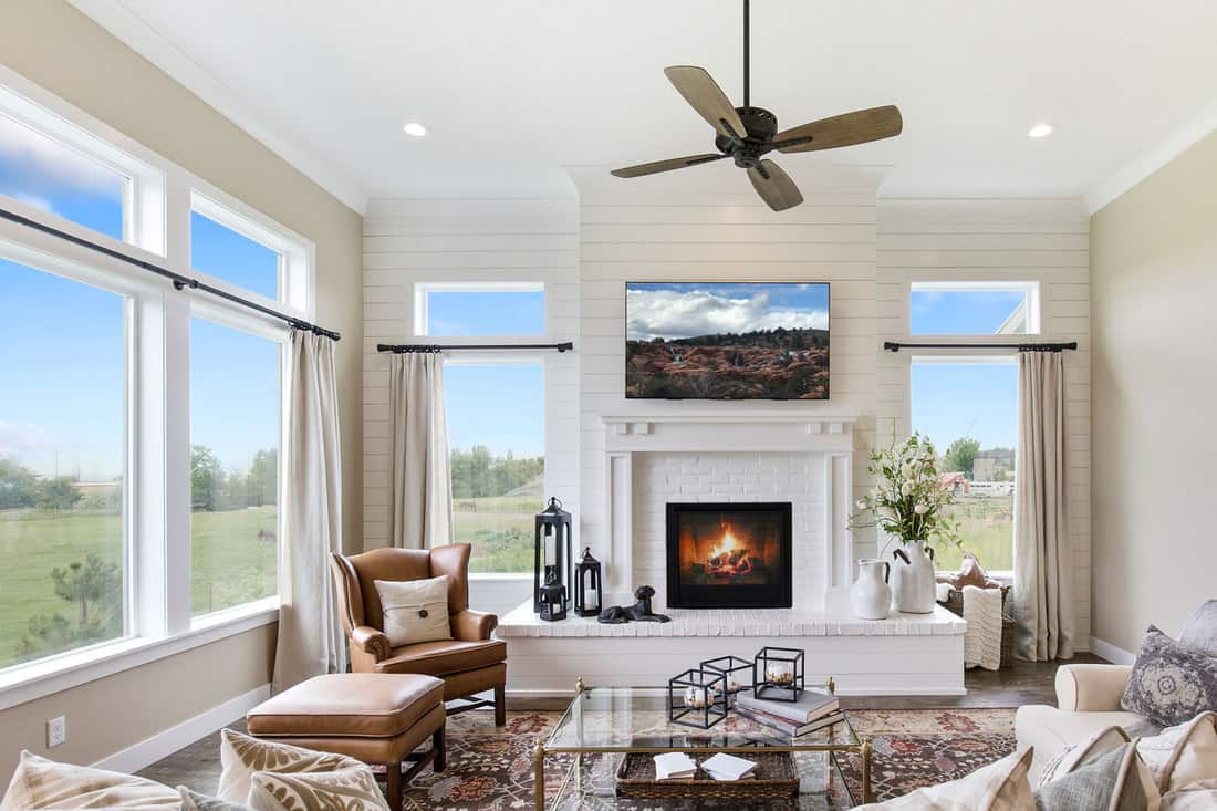 Ceiling fan hangs above gorgeous room with tall oversized windows, Can A Living Room Have No Windows?