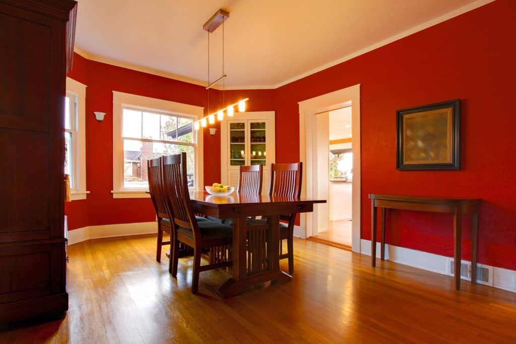Classic red dining room with antique furniture and cherry wood flooring