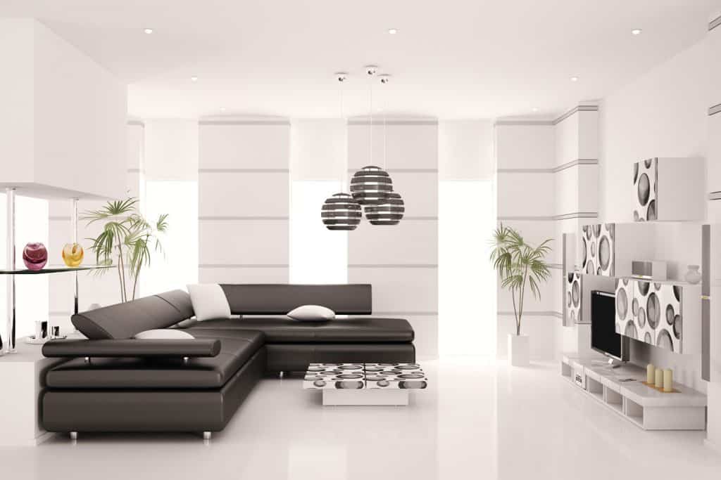 Contemporary living room with a long black sectional sofa, spherical gray dangling lamps, and an abstract themed TV area