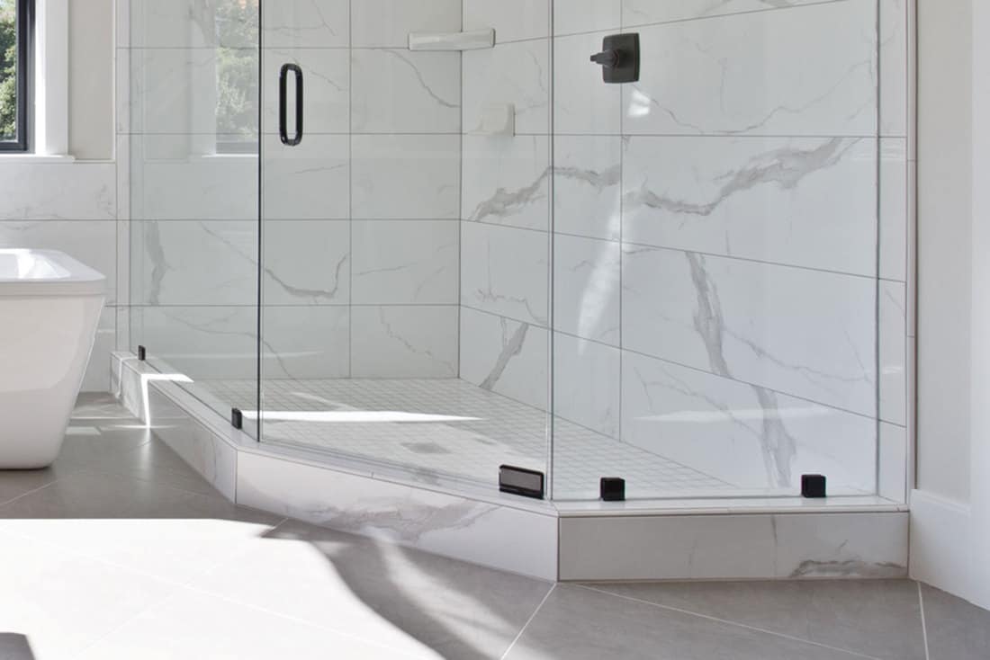 Shower glass with shower base and a marble tile in wall