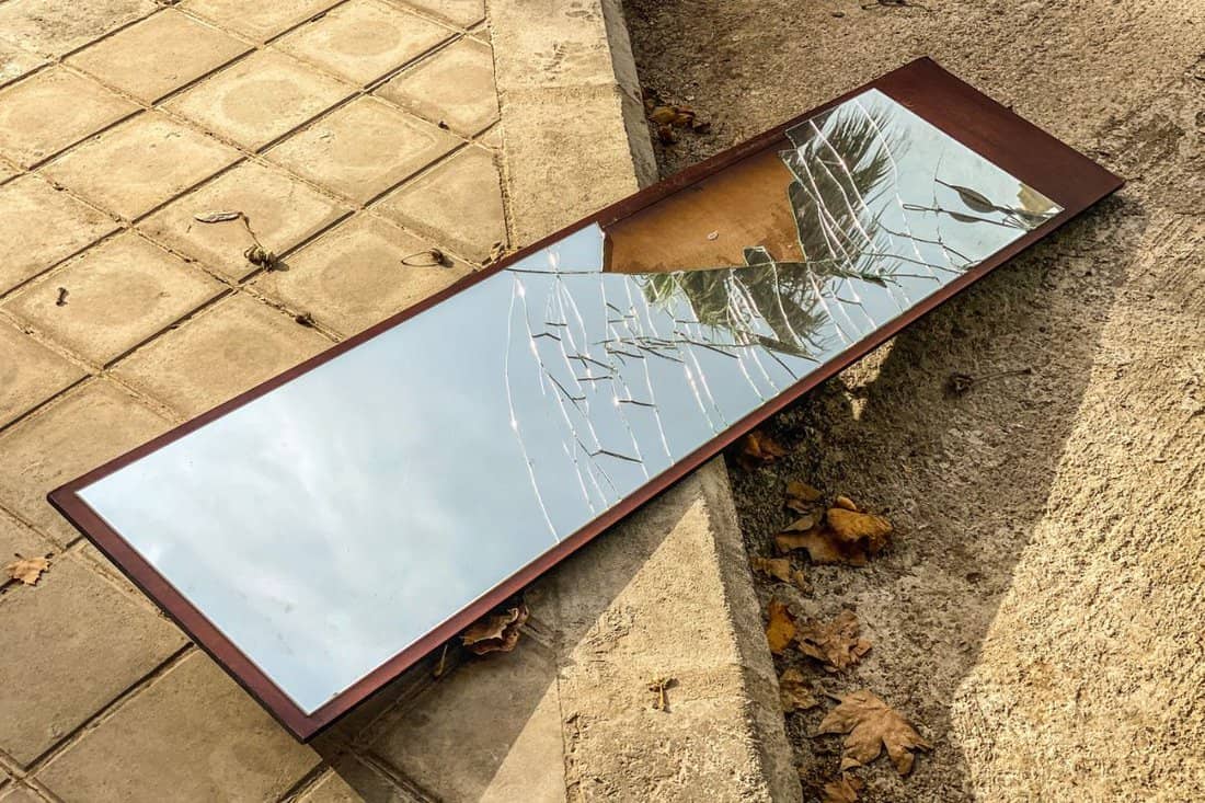 High angle view of broken mirror left in the street reflecting the sky