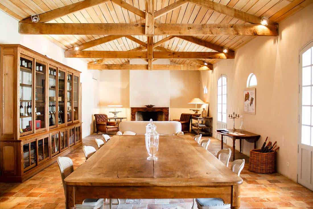 Home interior with roof beam, dining table and fireplace