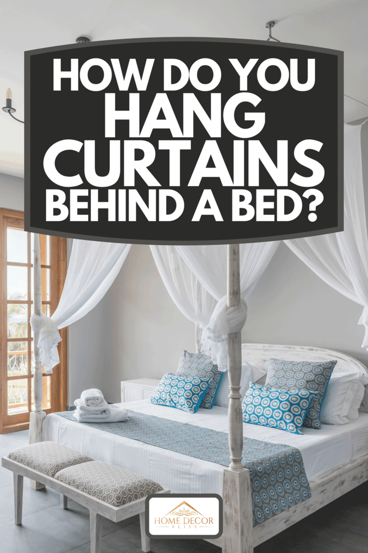 Lit à baldaquin avec moustiquaire dans une chambre d'hôtel lumineuse avec vue sur la plage sur le balcon, Comment accrochez-vous des rideaux derrière un lit ?