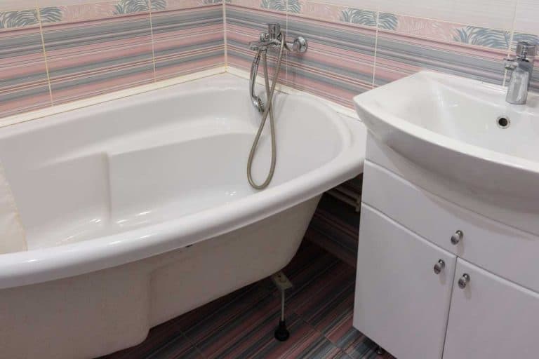 Interior of a cozy bathroom with a washbasin and a bathtub, How To Remove Silicone Caulk From Acrylic Tub In 4 Steps