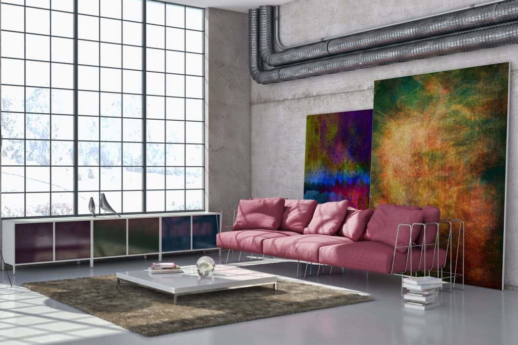 Interior of a large contemporary living room, an abstract canvas painting, and a long pink colored sectional sofa