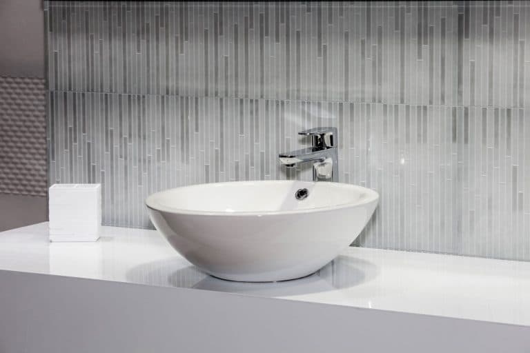 Interior of a modern bathroom with gorgeous tiles bathroom with a white ceramic sink, Why Does My Bathroom Sink Smell? [And What To Do About It]