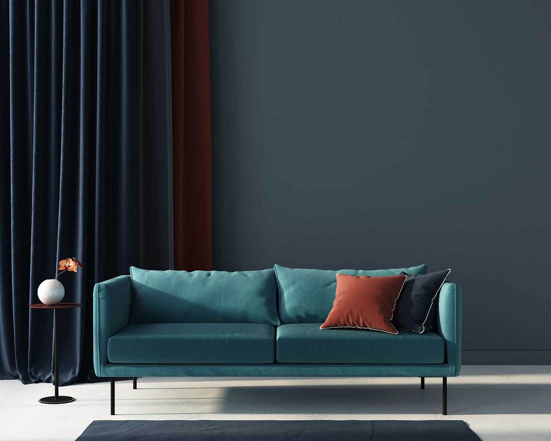 Interior of the living room in blue with a sofa, table and terracotta pillow