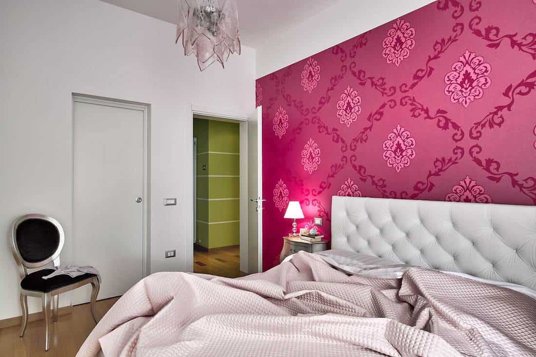Interior view of a modern bedroom with pink wallpaper