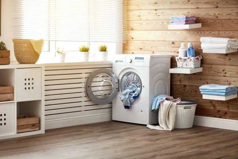 Laundry room with washing machine at window, hardwood floor and walls, 11 Farmhouse Laundry Room Ideas You Need To See