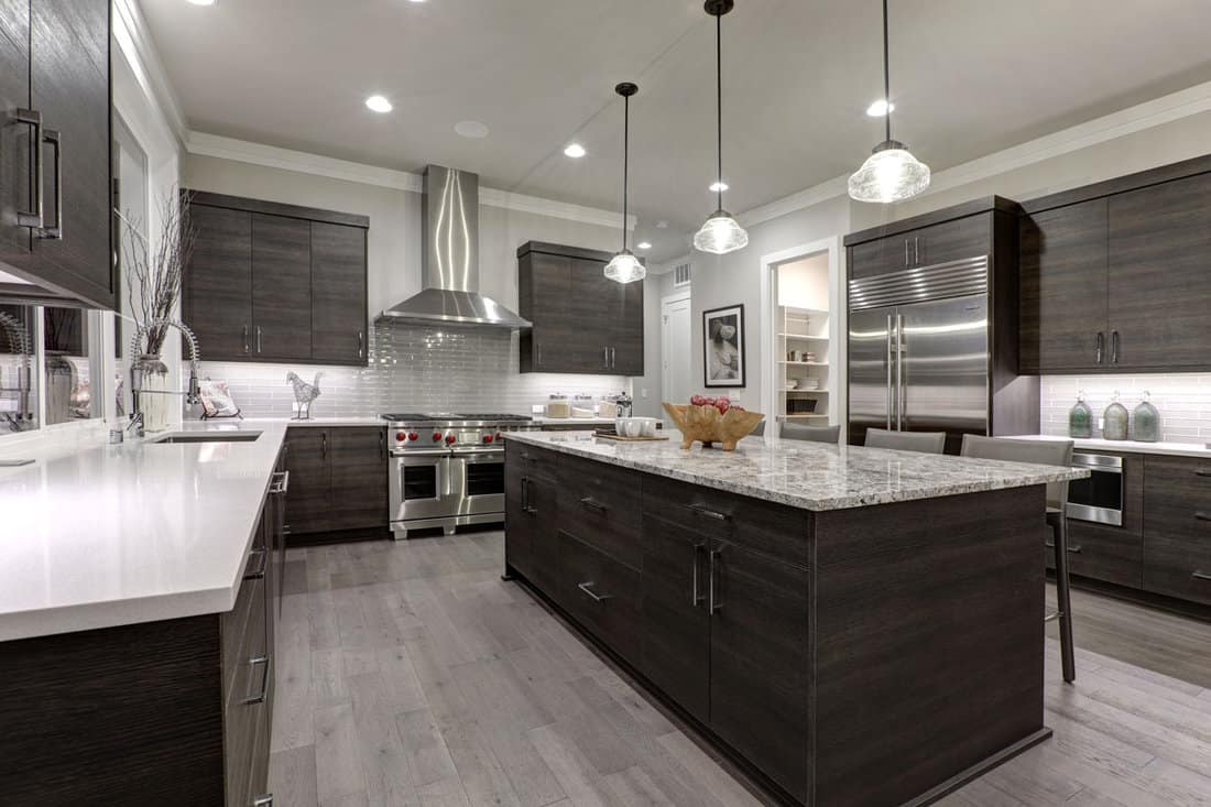 Luxurious kitchen with gray walls, white countertop and dark brown cabinets