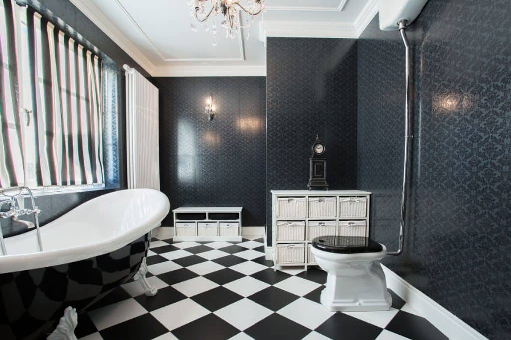 Luxurious modern bathroom with black and white flooring and matching black painted walls