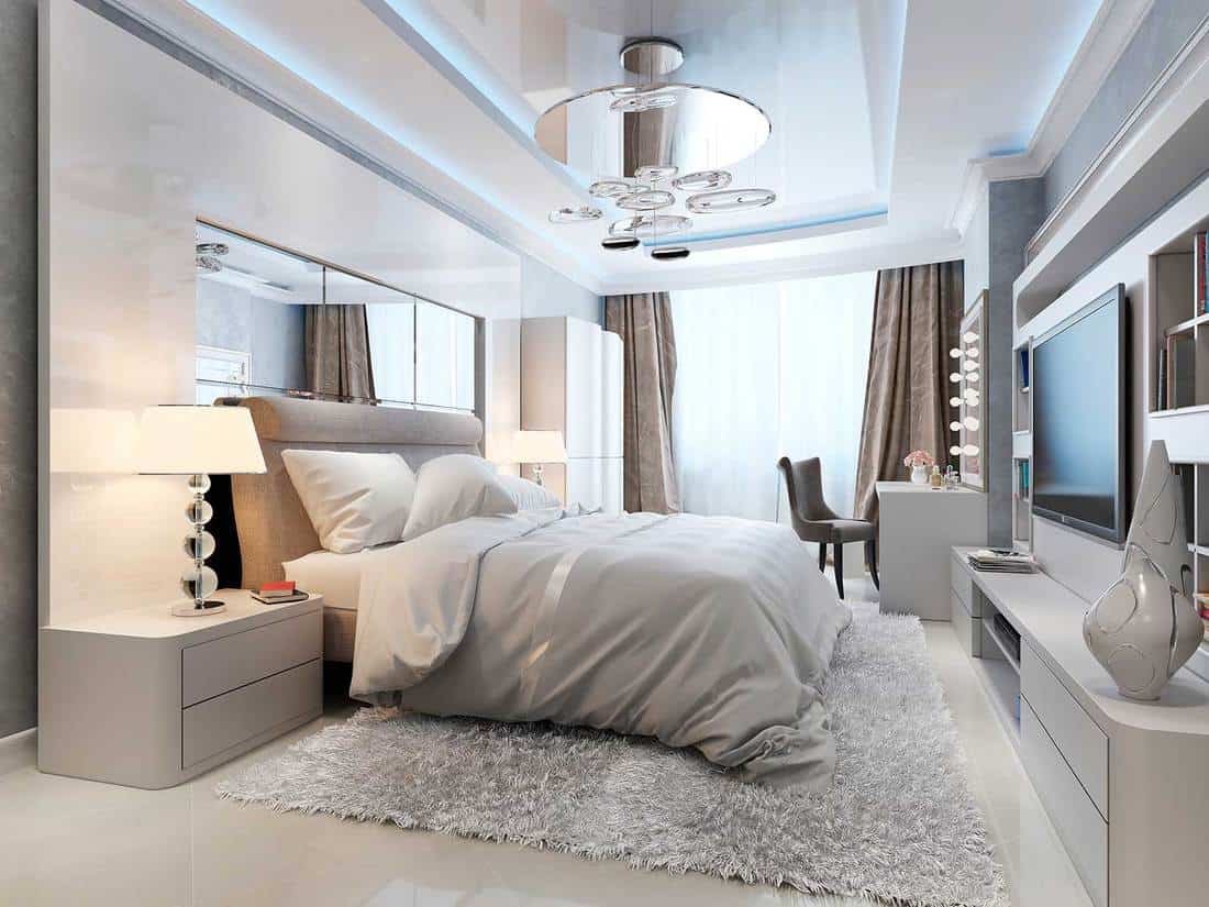 Luxury bedroom interior with cozy bed, vanity and TV