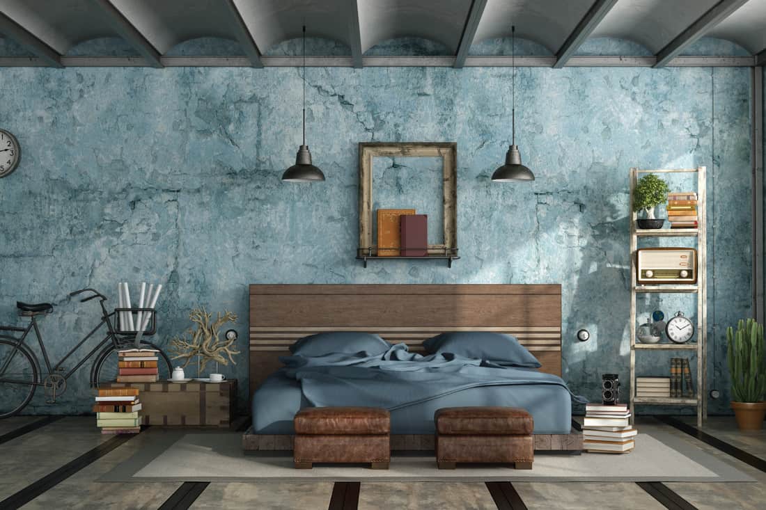 Master bedroom in industrial style with old blue wall and stacks of vintage books