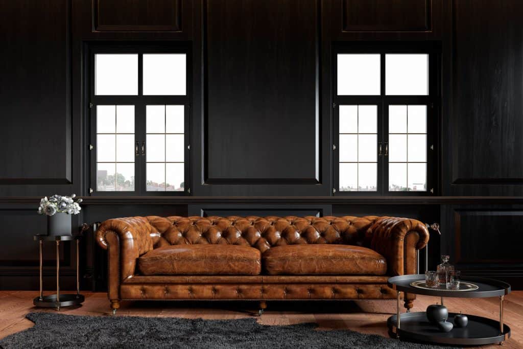 Intérieur sombre et moderne d'un salon contemporain avec un canapé en cuir sombre et un canapé abstrait sombre