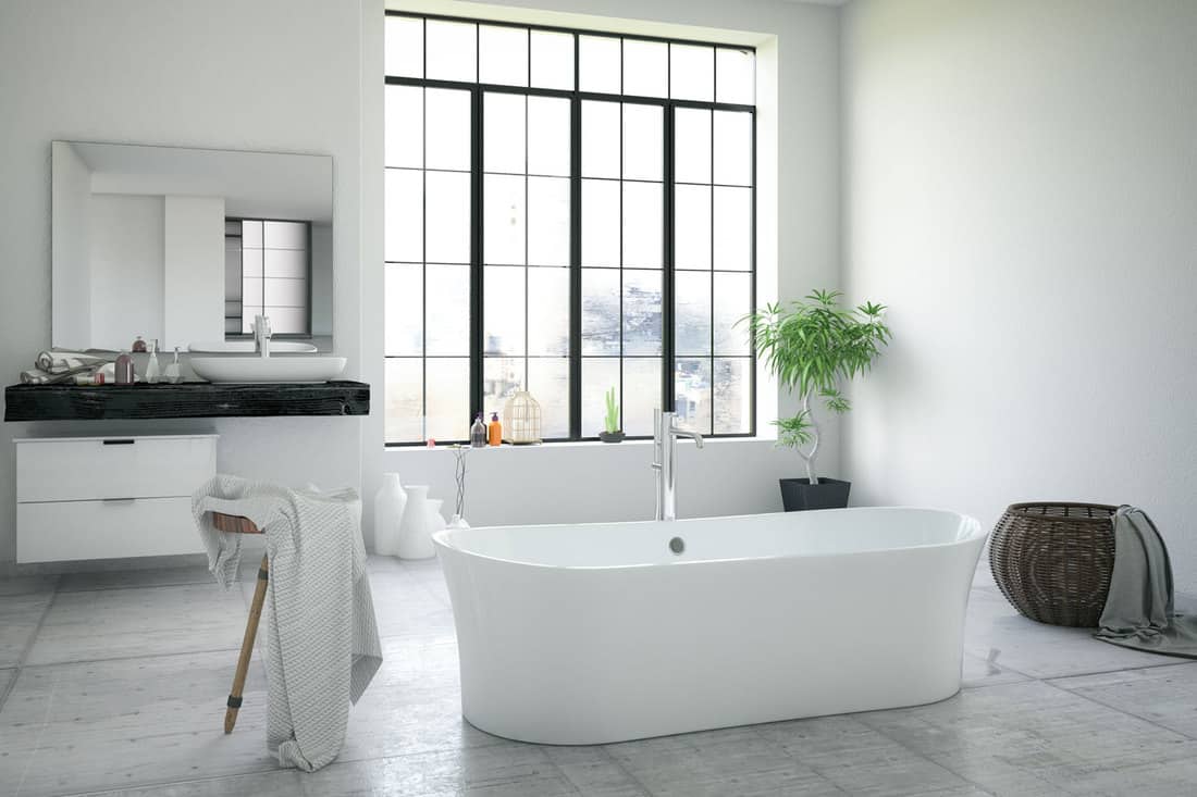Modern interior of a bathroom with white painted walls, huge white bathtub, and a minimalist themed bathroom vanity, How Big Is A Bathtub? [A Breakdown Of Standard Dimensions]